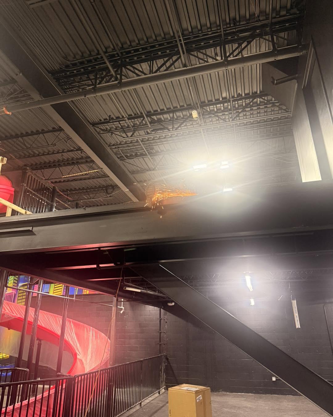 Interior demolition work with metal being cut near an overhead structure