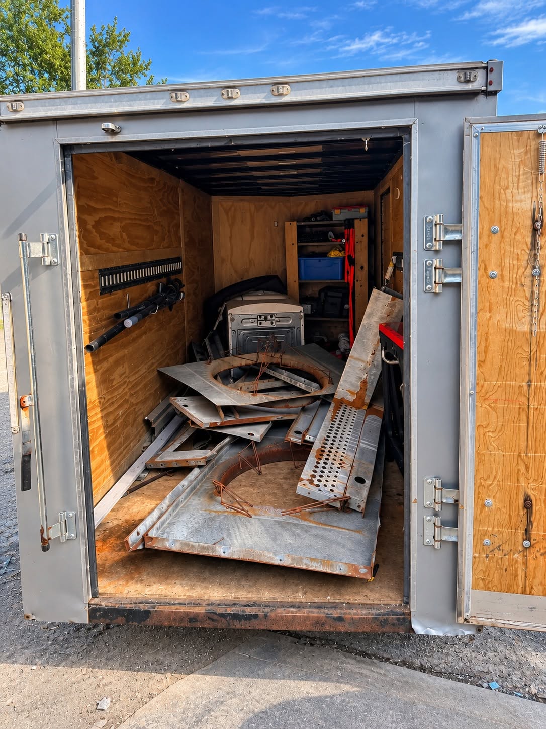 Enclosed trailer loaded with metal panels and debris
